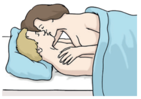 Ein Mann und eine Frau liegen übereinander im Bett und küssen sich